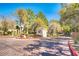 Community entrance with lush landscaping and a charming guard house at 8408 Running Deer Ave # 103, Las Vegas, NV 89145