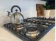 Close up of a stainless steel stove top with kettle at 9008 Cotton Rose Way, Las Vegas, NV 89134
