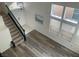Open living room with staircase, large windows with blinds, and modern gray wood flooring at 9008 Cotton Rose Way, Las Vegas, NV 89134