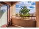 Private balcony with brown railings that overlooks the neighborhood with beautiful trees and blue skies at 9580 W Reno Ave # 211, Las Vegas, NV 89148