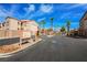 Amber Hills II entrance gate featuring desert landscaping, palm trees and a well-maintained road at 9580 W Reno Ave # 211, Las Vegas, NV 89148