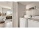 Convenient laundry room area with washer, dryer, and shelving for storage at 9580 W Reno Ave # 211, Las Vegas, NV 89148