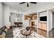 Open-plan living room flows into an eat-in kitchen with a dining table and an island, all illuminated by modern pendant lights at 9580 W Reno Ave # 211, Las Vegas, NV 89148