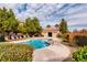 A pool area is set up with lounge chairs, palm trees, and a clubhouse at 9580 W Reno Ave # 211, Las Vegas, NV 89148