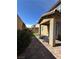 Relaxing backyard with a covered patio, brick pavers, lush shrubbery, and comfortable seating at 961 Spiracle Ave, Henderson, NV 89002