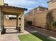 Inviting backyard with a covered patio, brick pavers, artificial turf, and a low brick wall with landscaping at 961 Spiracle Ave, Henderson, NV 89002
