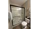 Bathroom with a glass door shower, white fixtures, and neutral tones at 961 Spiracle Ave, Henderson, NV 89002