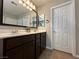 Bathroom features a double sink vanity with dark cabinets, white countertops, and a large framed mirror at 961 Spiracle Ave, Henderson, NV 89002