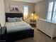 Cozy bedroom with a black wood-framed bed, white dresser, and a window with white shutters at 961 Spiracle Ave, Henderson, NV 89002