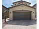 Beige two-story home featuring a brown two-car garage and a paved driveway at 961 Spiracle Ave, Henderson, NV 89002