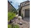 Home exterior featuring desert landscaping with rocks, plants, and a palm tree at 961 Spiracle Ave, Henderson, NV 89002