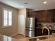 Kitchen featuring stainless steel refrigerator, dark wood cabinets, and granite counters at 961 Spiracle Ave, Henderson, NV 89002