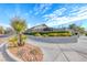 Landscaped community entrance featuring stone signage, mature trees, and manicured shrubs under a bright blue sky at 10479 Garden Light Dr, Las Vegas, NV 89135