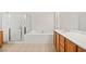 Bright bathroom featuring a bathtub, glass shower, and double vanity sink with cabinet at 11298 Merado Peak Dr, Las Vegas, NV 89135