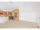 Well-lit room with tile flooring, a kitchen island with wooden cabinets and stainless steel appliances at 11298 Merado Peak Dr, Las Vegas, NV 89135