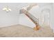 Bright foyer with staircase featuring wood handrail with iron balusters and neutral colored carpet at 11298 Merado Peak Dr, Las Vegas, NV 89135