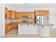 Modern kitchen with wooden cabinetry, a center island with granite countertop, and stone backsplash at 11298 Merado Peak Dr, Las Vegas, NV 89135