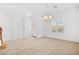 Spacious living room with neutral carpet, modern chandelier, and natural light from shuttered windows at 11298 Merado Peak Dr, Las Vegas, NV 89135