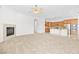 Spacious living room featuring a fireplace, neutral carpet, and an open connection to the modern kitchen at 11298 Merado Peak Dr, Las Vegas, NV 89135