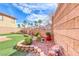 Lovely backyard featuring a garden, artificial grass, and privacy wall surrounded by picturesque desert landscaping at 1140 Paradise Vista Dr, Henderson, NV 89002