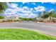 Community entrance featuring lush landscaping, decorative stone walls, and a paved roundabout at 1516 Dusty Canyon St, Henderson, NV 89052