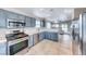 Modern kitchen featuring stainless steel appliances, blue cabinets, and tile flooring at 1516 Dusty Canyon St, Henderson, NV 89052