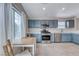 A charming kitchen with blue cabinets, stainless steel appliances and a small dining table at 1516 Dusty Canyon St, Henderson, NV 89052