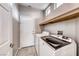Functional laundry room with modern washer, dryer, and ample shelving for storage convenience at 1516 Dusty Canyon St, Henderson, NV 89052
