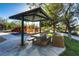 Community picnic area featuring a covered shelter with a grill, picnic table, and nearby playground at 1516 Dusty Canyon St, Henderson, NV 89052