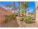 Backyard featuring desert landscaping, mature trees and a block wall at 1821 Eagle Mesa Ave, Henderson, NV 89012