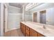 Bathroom featuring a dual sink vanity with wood cabinets and a large, glass-enclosed shower at 1821 Eagle Mesa Ave, Henderson, NV 89012