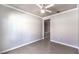 Bedroom featuring a ceiling fan, grey walls, white trim, wood-look flooring, and access to a closet at 1821 Eagle Mesa Ave, Henderson, NV 89012
