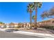Single-story home with desert landscaping, palm trees and two car garage on a sunny day at 1821 Eagle Mesa Ave, Henderson, NV 89012