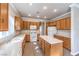 Well-lit kitchen featuring wood cabinets, central island, white appliances and light countertops at 1821 Eagle Mesa Ave, Henderson, NV 89012
