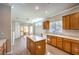 Open kitchen/living area with wood cabinets, central island, and sliding glass doors to outdoor patio at 1821 Eagle Mesa Ave, Henderson, NV 89012