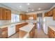 Well-lit kitchen featuring wood cabinets, central island, white appliances and light countertops at 1821 Eagle Mesa Ave, Henderson, NV 89012