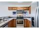 Well-lit kitchen featuring stainless steel appliances, granite countertops, and wooden cabinetry for a functional design at 2110 Sealion Dr # 101, Las Vegas, NV 89128