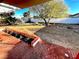 Fenced backyard with a tree and a red brick patio at 2208 E Ogden Ave, Las Vegas, NV 89101