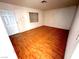 Well-lit bedroom with hardwood floors, a window, and a door to the side of the room at 2228 Saint Paul Way, Las Vegas, NV 89104