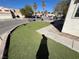 This bright front yard features drought-tolerant landscaping, manicured artificial turf, and concrete walkway at 2228 Saint Paul Way, Las Vegas, NV 89104