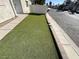 The tidy front yard features drought-resistant turf, and a concrete walkway from the sidewalk at 2228 Saint Paul Way, Las Vegas, NV 89104