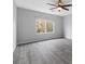 This bedroom features wood look floors, a ceiling fan, and a large window at 2231 Desert Prairie St, Las Vegas, NV 89135