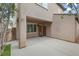 A covered patio on the side of the house offers a cozy outdoor space, complemented by neutral stucco and mature trees at 2231 Desert Prairie St, Las Vegas, NV 89135