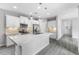 Modern kitchen with white cabinets, quartz countertops, stainless steel appliances, and gray wood flooring at 2231 Desert Prairie St, Las Vegas, NV 89135