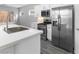 Bright kitchen with stainless steel appliances, gray wood floors, quartz counters, and ample cabinet space at 2231 Desert Prairie St, Las Vegas, NV 89135