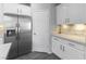 Well-lit kitchen boasts stainless steel appliances, quartz countertops, white cabinets, and gray wood floors at 2231 Desert Prairie St, Las Vegas, NV 89135