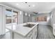 Open kitchen features an island, quartz countertops, stainless steel faucet, and sliding glass doors at 2231 Desert Prairie St, Las Vegas, NV 89135