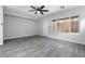 Open living room with gray wood floors, ceiling fan, and large window for natural light at 2231 Desert Prairie St, Las Vegas, NV 89135