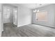 Bright living room featuring gray wood floors, a modern chandelier, and natural light through the window at 2231 Desert Prairie St, Las Vegas, NV 89135
