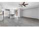 Open-concept living room features gray wood flooring, a ceiling fan, and seamless kitchen access at 2231 Desert Prairie St, Las Vegas, NV 89135